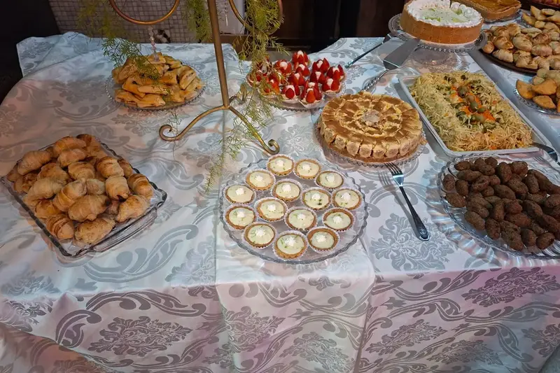 Mesa de coffee break com doces e salgados